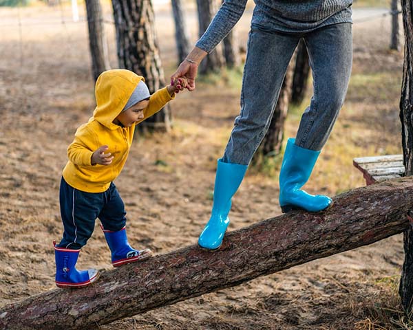 A woman and child standing on a log.